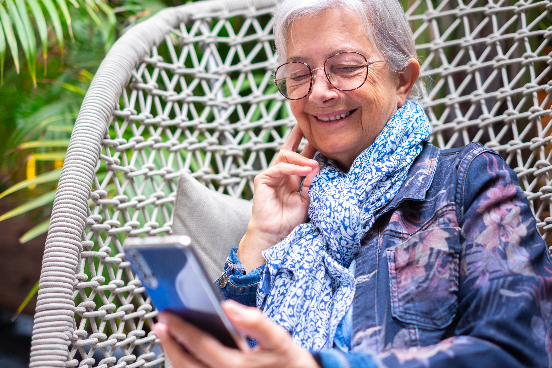 Adulta mayor relajada al aire libre usando su teléfono